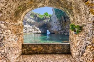 Balcon avec arche en pierre donnant sur une belle piscine naturelle idyllique à Sorrente